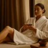 Spa salonunda bornoz giymiş kadın, masaj sonrası dinlenme alanında huzurlu bir an yaşıyor